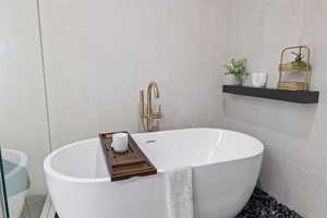 Full bathroom with tile walls and a freestanding bath