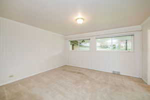 Unfurnished room with ornamental molding and carpet floors