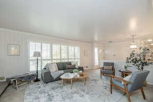 Carpeted living room featuring crown molding and baseboards