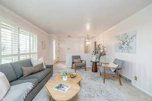 Living area with ornamental molding and carpet floors