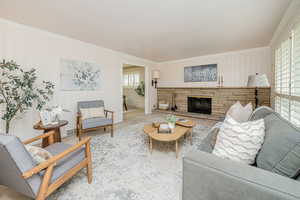 Living room featuring wallpapered walls, ornamental molding, and a fireplace