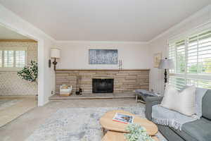 Tiled living area featuring a fireplace, ornamental molding, and wallpapered walls