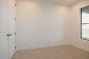 Empty room with baseboards and light carpet
