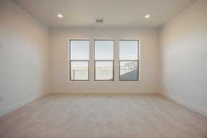 Spare room with light carpet and recessed lighting