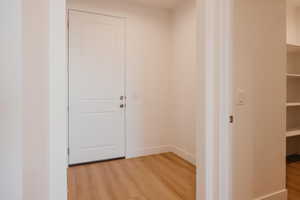 Hall with light wood-type flooring and baseboards