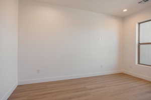 Spare room with light wood-style floors and recessed lighting