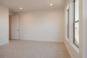 Spare room with light carpet and recessed lighting