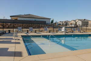 Community pool featuring a patio and a residential view