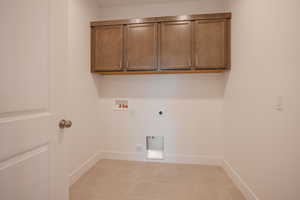 Washroom featuring hookup for a washing machine, electric dryer hookup, and cabinet space