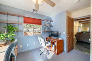 Office with carpet, ceiling fan, and beam ceiling