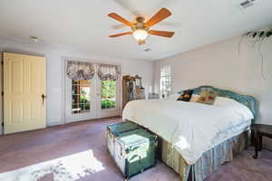 Bedroom with access to outside, carpet floors, and a ceiling fan