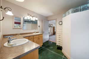 Bathroom with double vanity and concrete floors