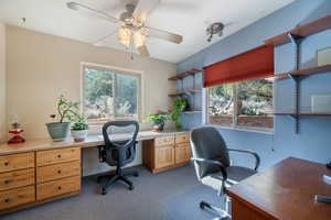 Office with plenty of natural light, dark carpet, and a ceiling fan