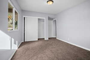 Unfurnished bedroom featuring carpet floors and a closet