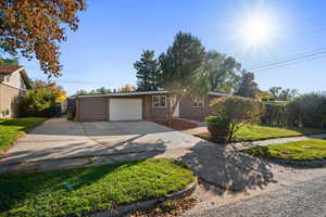 Single story home featuring concrete driveway and an attached garage