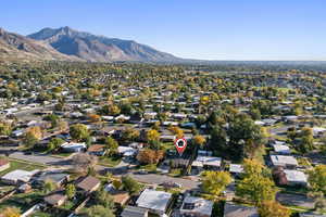 Aerial view of property and surrounding area featuring mountains and nearby suburban area