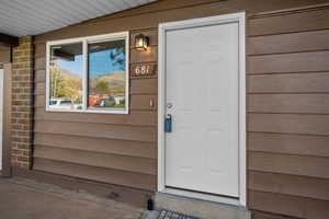View of exterior entry featuring covered porch