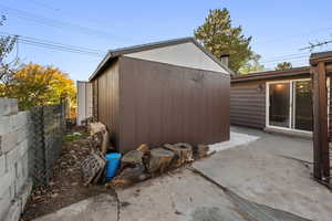 View of home's exterior featuring a storage unit and a patio