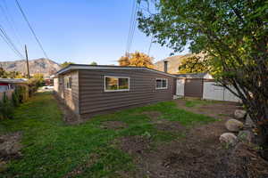 Back of property with a fenced backyard, a mountain view, and an outbuilding