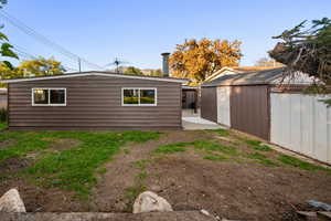 Back of house featuring a patio and a shed