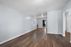 Empty room featuring dark wood finished floors and a textured ceiling