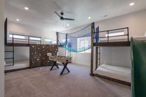 Carpeted bedroom with multiple windows, recessed lighting, a textured ceiling, and a ceiling fan