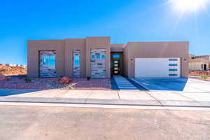 View of front of property featuring stucco siding, driveway, and a garage