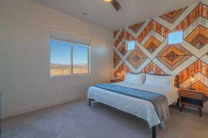 Bedroom with an accent wall, carpet flooring, and a ceiling fan