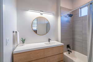 Full bathroom with shower / tub combo and vanity