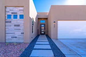 Entrance to property with stucco siding and stone siding
