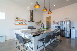 Kitchen with finished concrete floors, open shelves, a kitchen bar, stainless steel appliances, and recessed lighting