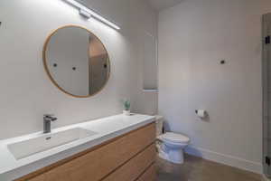 Full bath featuring concrete floors, vanity, and a stall shower