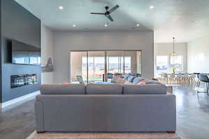 Living area with finished concrete floors, a textured ceiling, healthy amount of natural light, recessed lighting, and ceiling fan