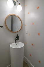 Bathroom featuring baseboards and a sink