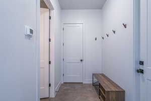 Mudroom with concrete flooring and baseboards