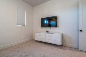 Bedroom featuring light carpet