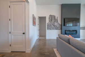 Corridor featuring finished concrete flooring and baseboards