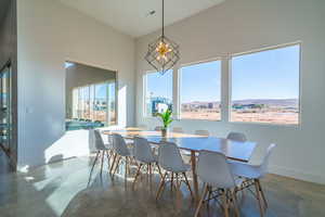 Dining area featuring concrete flooring and a high ceiling