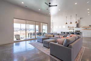 Living room with finished concrete floors, recessed lighting, a ceiling fan, and a textured ceiling
