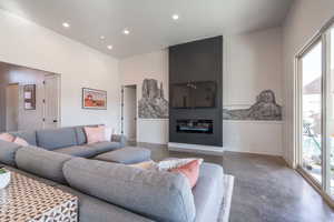 Living room featuring concrete floors, recessed lighting, and a fireplace