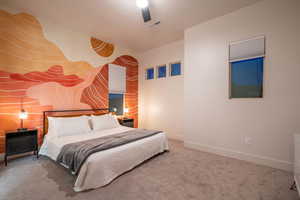 Carpeted bedroom with a ceiling fan and an accent wall
