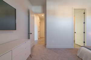 Bedroom with light colored carpet and connected bathroom