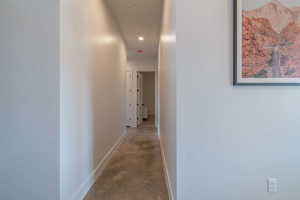 Hall featuring concrete flooring and recessed lighting