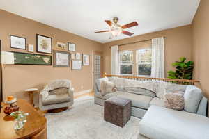Living room featuring ceiling fan and baseboards
