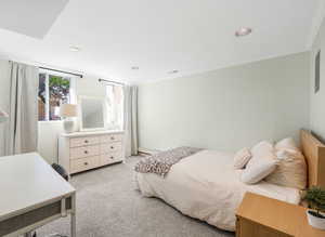 Bedroom with light carpet, ornamental molding, a baseboard heating unit, and recessed lighting
