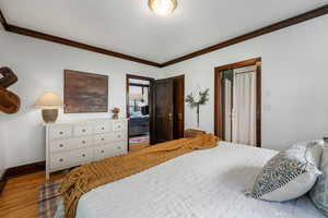 Bedroom with crown molding and wood finished floors