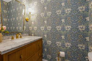 Bathroom featuring vanity and wallpapered walls