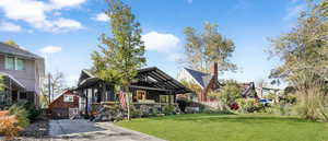 View of front of home featuring a front lawn, a garage, and an outdoor structure