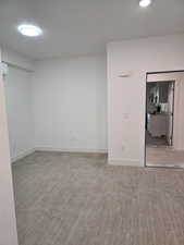 Room with a textured ceiling, light wood finished floors, and recessed lighting