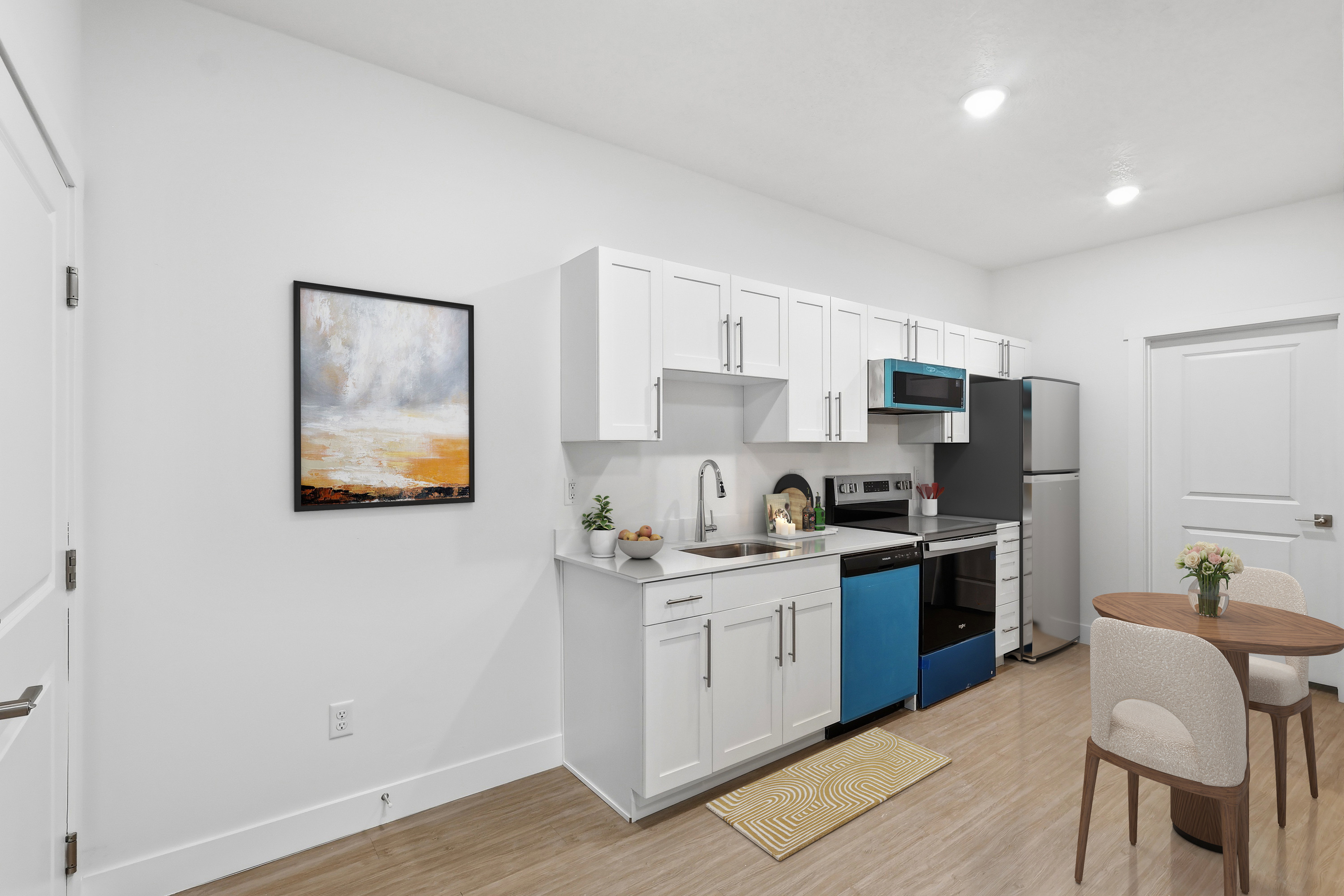 Kitchen featuring white cabinetry, light-toned countertops, and wood-finish flooring